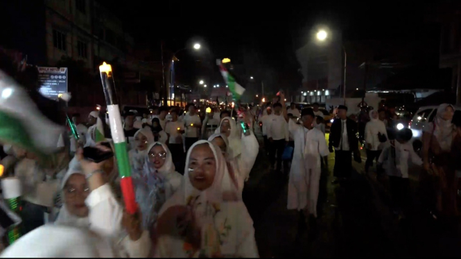 Warga pawai obor bawa bendera Palestina