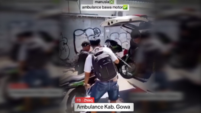 Petugas menurunkan motor dari dalam ambulans