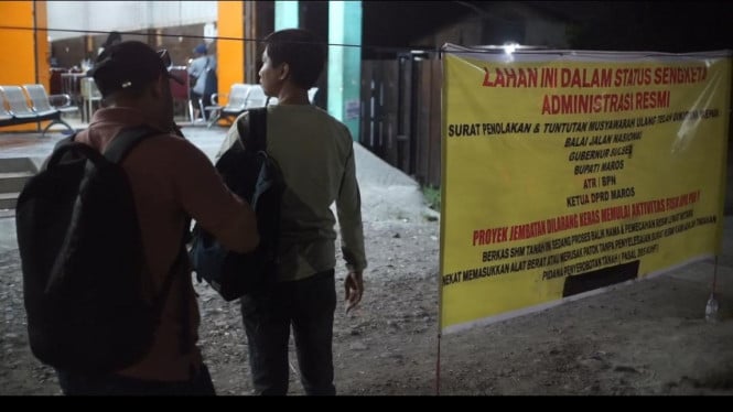 Warga memasang spanduk penolakan proyek Duplikat Jembatan Maros.