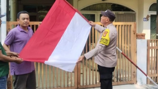 Polisi membagikan bendera kepada warga di wilayah Grogol Petamburan