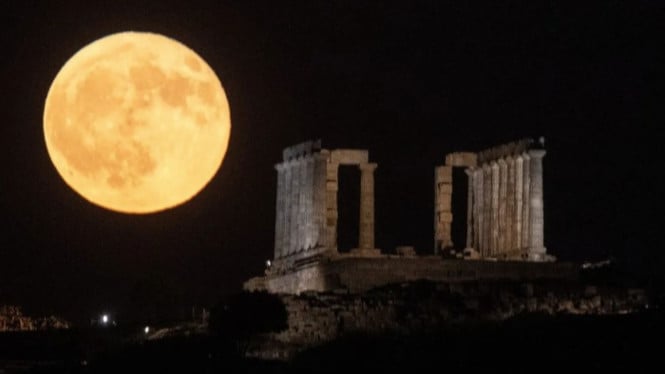 Bulan purnama terbit di atas Kuil Kuno Poseidon di Cape Sounion Yunani
