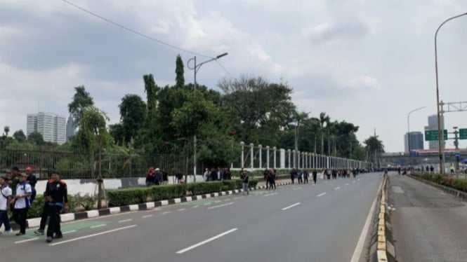 Puluhan buruh berjalan meninggalkan lokasi pusat aksi unjuk rasa