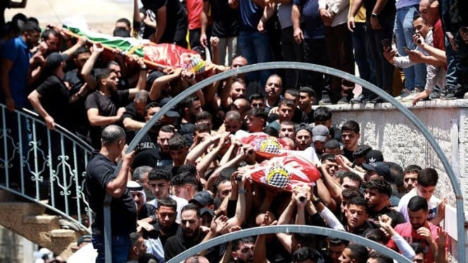 Warga palestina membawa tiga jenazah kerabat mereka yang tewas
