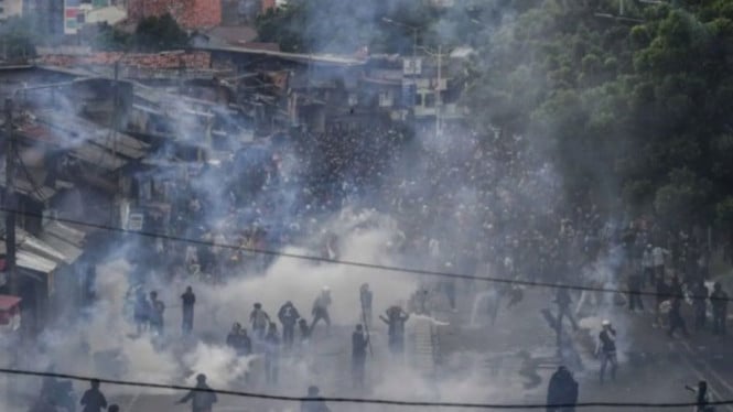 Pengunjuk rasa menghindari tembakan gas air mata di Pejompongan