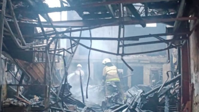 Sejumlah petugas damkar melakukan pendinginan di lokasi kebakaran