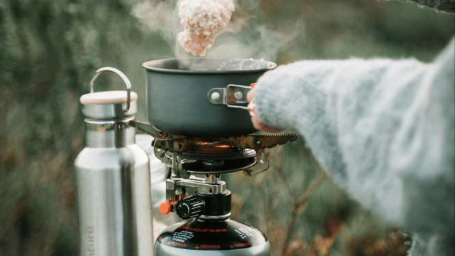 A Person Cooking Oatmeal using Portable Stove
