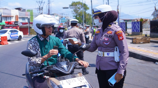Ipda Popy Puspasari memberikan masker kepada pengendara sepeda motor