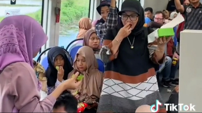 Bagi-bagi dan Makan Kue Bersama di Dalam Kereta