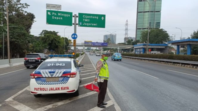 Polisi Berjaga untuk Menjaga Kelancaran Lalu Lintas di Jalan