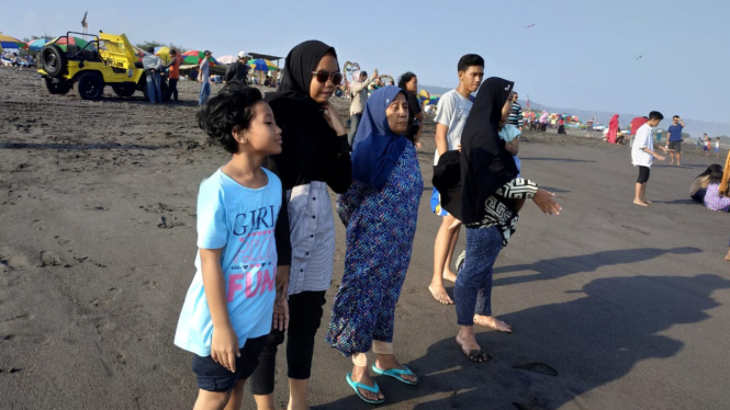 Wisatawan Mengunjungi Lokasi Wisata di Pantai Parangtritis, Yogyakarta